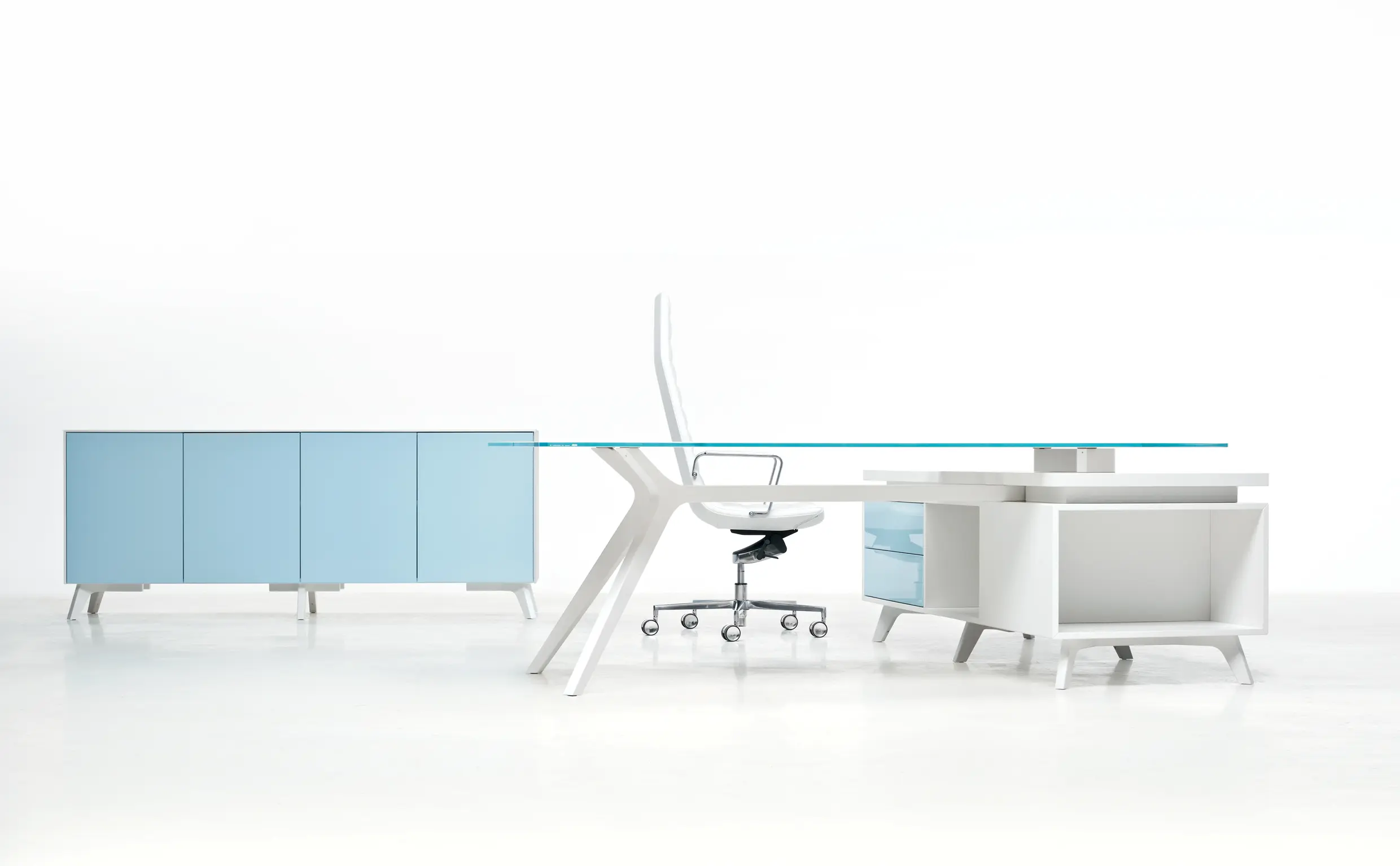 DEKKO Interiors | Αισθητική & Εργονομία στα Έπιπλα Γραφείου Η κατασκευή του γραφείου αποπνέει μια ευάερη και δυναμική αίσθηση, χάρη στην ξύλινη δομή του, η οποία είναι εμπνευσμένη από το στυλ "Mollinian". Αυτή η μοναδική κατασκευή στηρίζει είτε μια γυάλινη είτε μια ξύλινη επιφάνεια σε μια εντυπωσιακή ισορροπία αντίθετων δυνάμεων, δημιουργώντας ένα εντυπωσιακό οπτικό αποτέλεσμα. Το πολύτιμο ξύλο καρυδιάς παίζει κεντρικό ρόλο στον σχεδιασμό του γραφείου. Η επιφάνεια εργασίας, κατασκευασμένη από φυσικό καρυδιά ξύλο, είναι το αποκορύφωμα της υλικότητας και της χειροτεχνίας, με ένα συμπαγές προφίλ και στρογγυλεμένες άκρες που αναδεικνύουν τη φυσική ομορφιά του υλικού. Η γοητεία του κρυστάλλου συναντά την ισχυρή και στιβαρή αίσθηση του μαόνι kotibé στη δομή του γραφείου. Προτείνεται σε δύο εκδόσεις: λευκή και ανθρακί λάκα, προσφέροντας έτσι ευελιξία στον σχεδιασμό του εσωτερικού χώρου. Οι κρυστάλλινες επιφάνειες είναι διαθέσιμες σε τρεις εκδόσεις: εξαιρετικά διαφανές γυαλί, λευκό λακαρισμένο γυαλί, και καπνιστό γυαλί, όλα πάχους 15 mm, προσδίδοντας μία επιπλέον διάσταση πολυτέλειας.