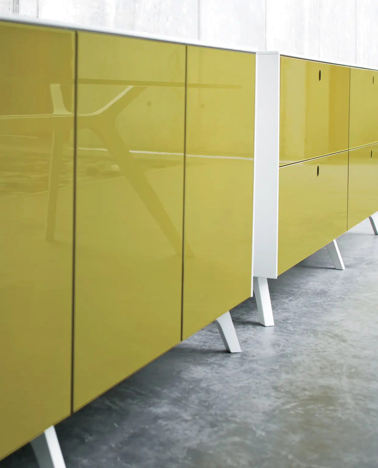 DEKKO Interiors | Αισθητική & Εργονομία στα Έπιπλα Γραφείου Η κατασκευή του γραφείου αποπνέει μια ευάερη και δυναμική αίσθηση, χάρη στην ξύλινη δομή του, η οποία είναι εμπνευσμένη από το στυλ "Mollinian". Αυτή η μοναδική κατασκευή στηρίζει είτε μια γυάλινη είτε μια ξύλινη επιφάνεια σε μια εντυπωσιακή ισορροπία αντίθετων δυνάμεων, δημιουργώντας ένα εντυπωσιακό οπτικό αποτέλεσμα. Το πολύτιμο ξύλο καρυδιάς παίζει κεντρικό ρόλο στον σχεδιασμό του γραφείου. Η επιφάνεια εργασίας, κατασκευασμένη από φυσικό καρυδιά ξύλο, είναι το αποκορύφωμα της υλικότητας και της χειροτεχνίας, με ένα συμπαγές προφίλ και στρογγυλεμένες άκρες που αναδεικνύουν τη φυσική ομορφιά του υλικού. Η γοητεία του κρυστάλλου συναντά την ισχυρή και στιβαρή αίσθηση του μαόνι kotibé στη δομή του γραφείου. Προτείνεται σε δύο εκδόσεις: λευκή και ανθρακί λάκα, προσφέροντας έτσι ευελιξία στον σχεδιασμό του εσωτερικού χώρου. Οι κρυστάλλινες επιφάνειες είναι διαθέσιμες σε τρεις εκδόσεις: εξαιρετικά διαφανές γυαλί, λευκό λακαρισμένο γυαλί, και καπνιστό γυαλί, όλα πάχους 15 mm, προσδίδοντας μία επιπλέον διάσταση πολυτέλειας.