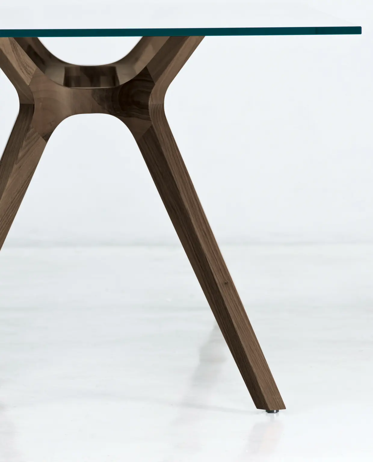 DEKKO Interiors | Αισθητική & Εργονομία στα Έπιπλα Γραφείου Η κατασκευή του γραφείου αποπνέει μια ευάερη και δυναμική αίσθηση, χάρη στην ξύλινη δομή του, η οποία είναι εμπνευσμένη από το στυλ "Mollinian". Αυτή η μοναδική κατασκευή στηρίζει είτε μια γυάλινη είτε μια ξύλινη επιφάνεια σε μια εντυπωσιακή ισορροπία αντίθετων δυνάμεων, δημιουργώντας ένα εντυπωσιακό οπτικό αποτέλεσμα. Το πολύτιμο ξύλο καρυδιάς παίζει κεντρικό ρόλο στον σχεδιασμό του γραφείου. Η επιφάνεια εργασίας, κατασκευασμένη από φυσικό καρυδιά ξύλο, είναι το αποκορύφωμα της υλικότητας και της χειροτεχνίας, με ένα συμπαγές προφίλ και στρογγυλεμένες άκρες που αναδεικνύουν τη φυσική ομορφιά του υλικού. Η γοητεία του κρυστάλλου συναντά την ισχυρή και στιβαρή αίσθηση του μαόνι kotibé στη δομή του γραφείου. Προτείνεται σε δύο εκδόσεις: λευκή και ανθρακί λάκα, προσφέροντας έτσι ευελιξία στον σχεδιασμό του εσωτερικού χώρου. Οι κρυστάλλινες επιφάνειες είναι διαθέσιμες σε τρεις εκδόσεις: εξαιρετικά διαφανές γυαλί, λευκό λακαρισμένο γυαλί, και καπνιστό γυαλί, όλα πάχους 15 mm, προσδίδοντας μία επιπλέον διάσταση πολυτέλειας.